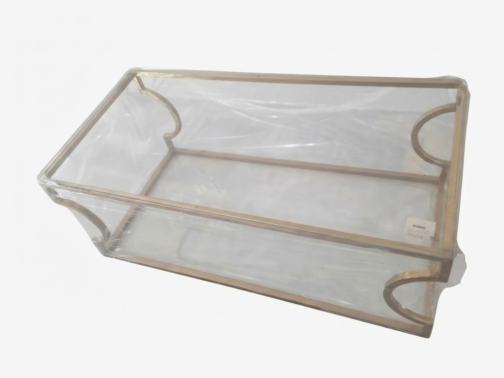 Clear tempered glass coffee table with curved chrome metal base for modern living room décor in Lagos Nigeria