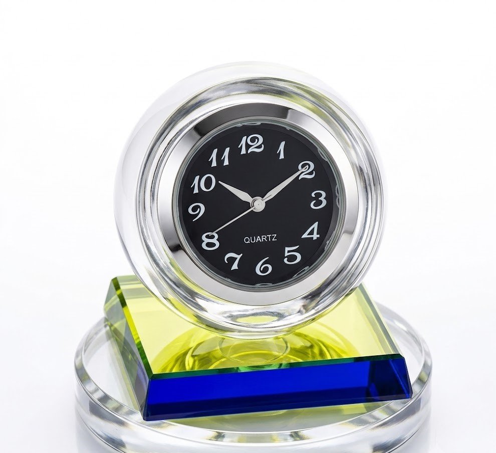 Crystal ball table clock with a black face and white numerals on a tiered multi-colour glass base in Lagos, Nigeria.