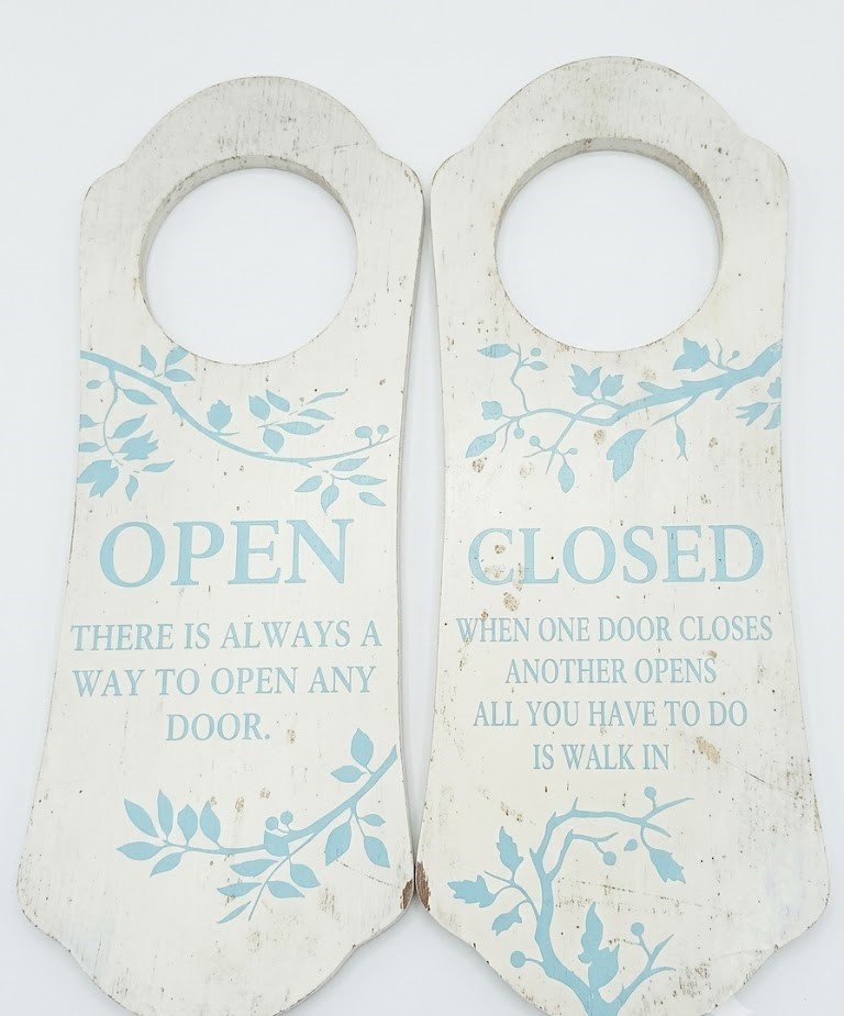 White vintage-style wooden door hanger with blue floral details and inspirational Open/Closed text in Lagos, Nigeria
