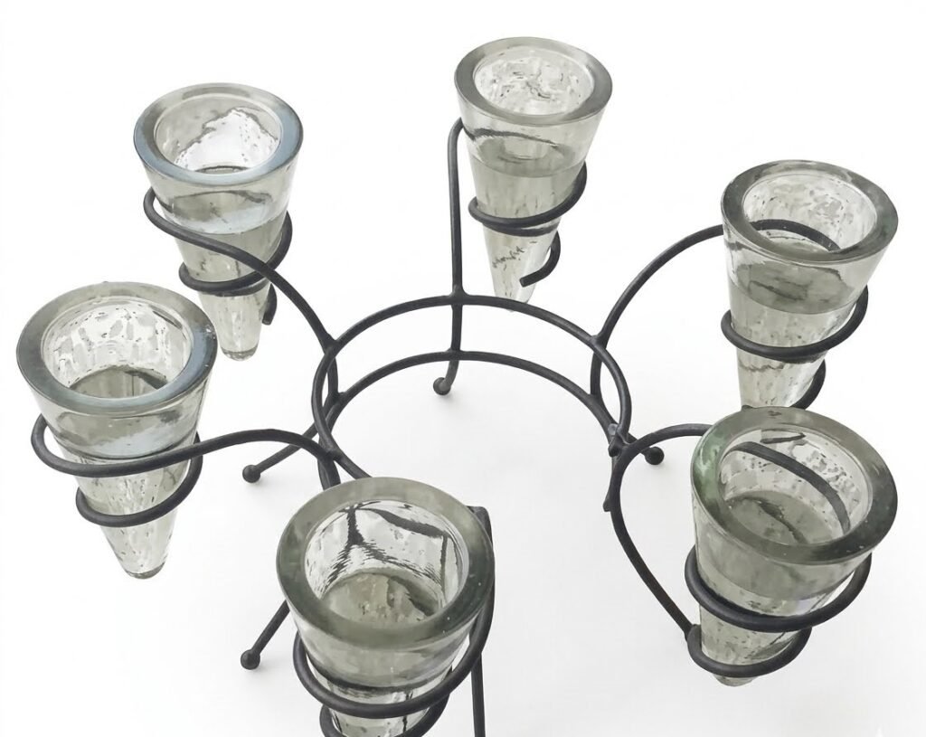 Clear glass cylindrical pillar candle holder featuring a sleek black metal ring base, Lagos, Nigeria