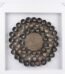 Framed 3D wall art with dark rolled paper circles and woven center in a distressed white frame in Lagos, Nigeria