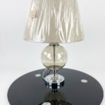 Modern side table lamp with a gold funnel shade and clear glass base for luxury decor in Lagos, Nigeria.
