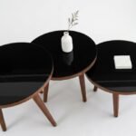 Set of 3 round nesting side stools with black glass tops and walnut tapered legs in Lagos, Nigeria