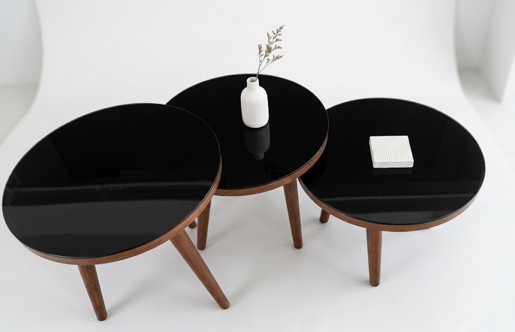 Set of 3 round nesting side stools with black glass tops and walnut tapered legs in Lagos, Nigeria