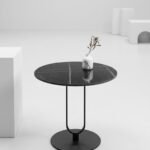 Modern round black sintered stone side table with white marble veining and metal pedestal base in Lagos, Nigeria.
