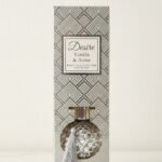 Silver round diamond-textured Desire Vanilla & Anise reed diffuser with a tassel in a silver gift box, Lagos, Nigeria