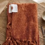 Terracotta throw blanket soft woven fabric draped on sofa for cozy home decor in Lagos Nigeria modern living room style