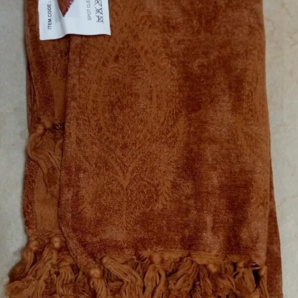 Terracotta throw blanket soft woven fabric draped on sofa for cozy home decor in Lagos Nigeria modern living room style