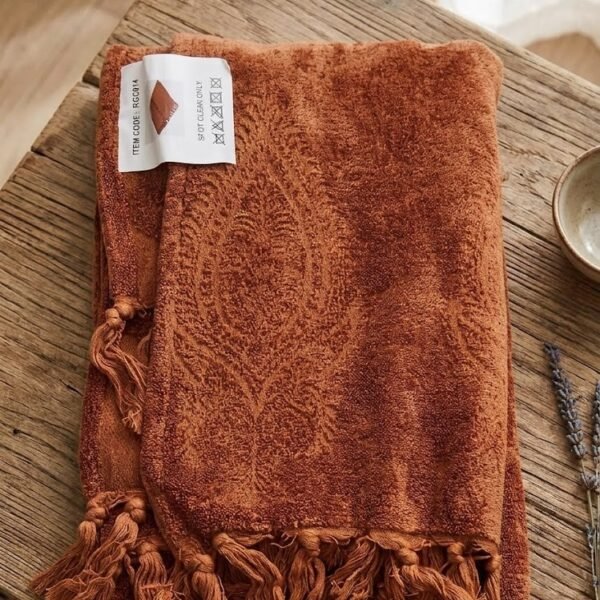 Terracotta throw blanket soft woven fabric draped on sofa for cozy home decor in Lagos Nigeria modern living room style