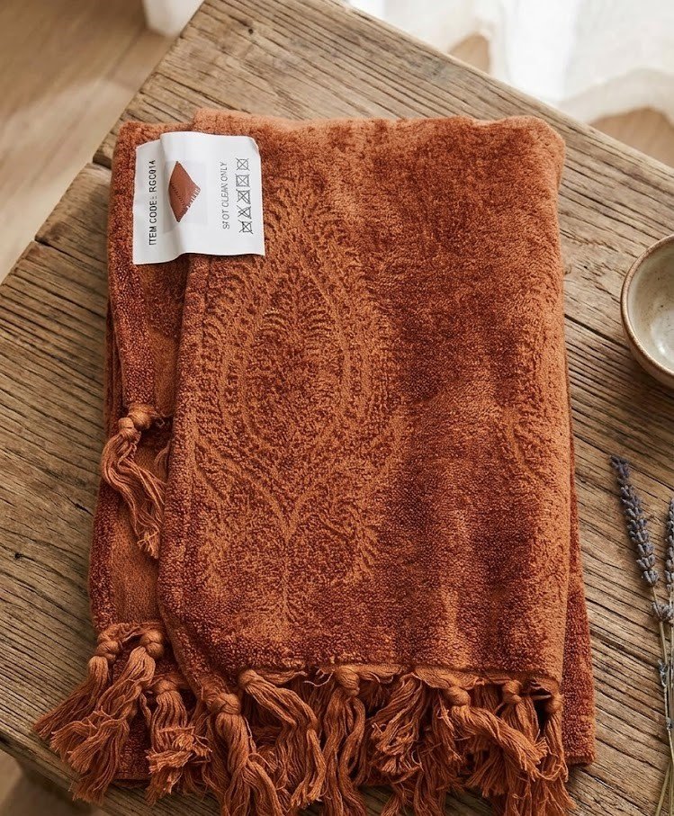 Terracotta throw blanket soft woven fabric draped on sofa for cozy home decor in Lagos Nigeria modern living room style