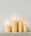 Elegant white pillar candle with a metallic silver silhouette pattern, 140x70mm for home decor in Lagos.